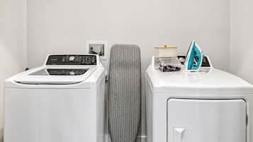 A laundry area with a front-loading washer, a dryer, and a utility cabinet.
