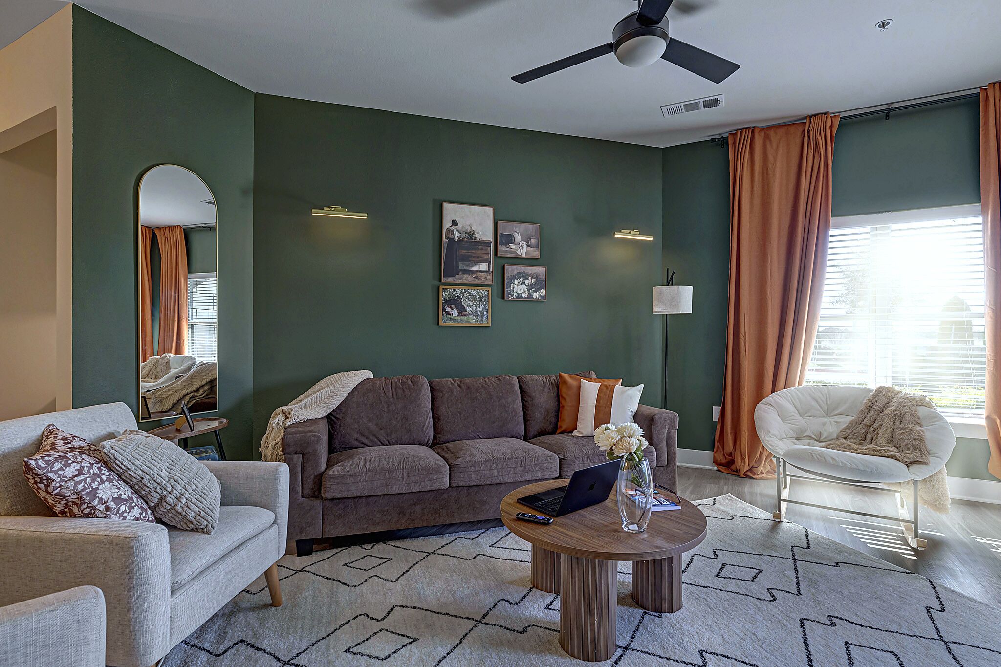 Een woonkamer met een bank, fauteuil, salontafel en kunstwerk aan de muur.