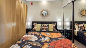 A hotel room with a large bed, two bedside tables with lamps, a mirror, and a ceiling light. - The Hive | Patio | Walk Downtown | Beach Gear (St. Petersburg)
