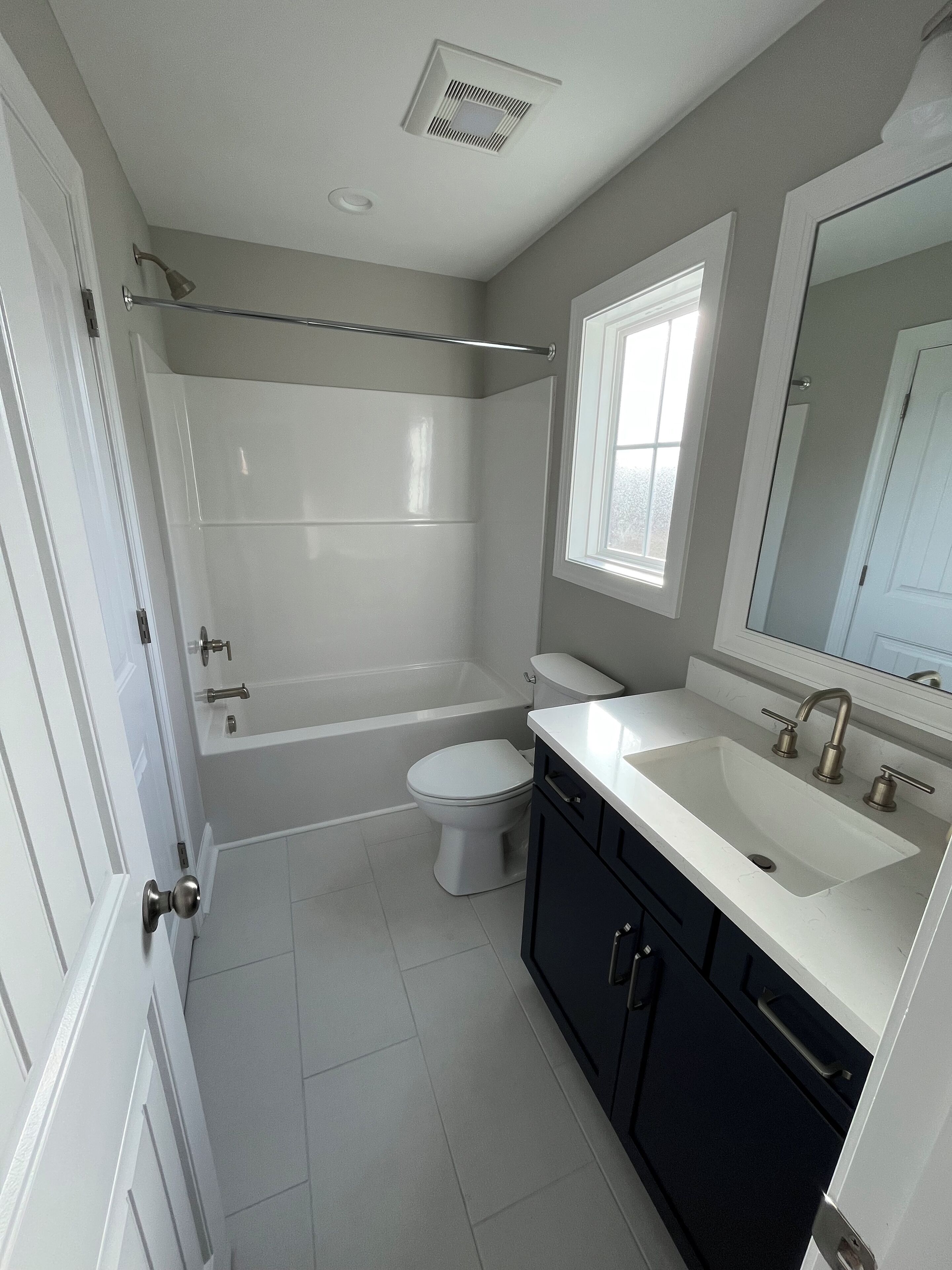 A bathroom with a bathtub, toilet, and sink.