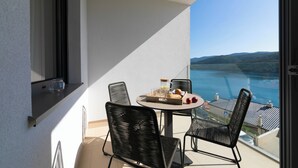 Ein Balkon mit Tisch, Stühlen und Meerblick.
