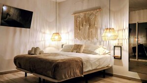 A modern bedroom with a large bed, two bedside lamps, and a wall-mounted TV. - Boutique accommodation with pool and sea views. 20 guests! (Benalmádena)