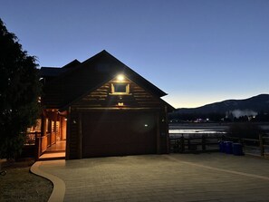 Eine Blockhütte mit Garage, überdachtem Gang und Blick auf ein Gebirge.