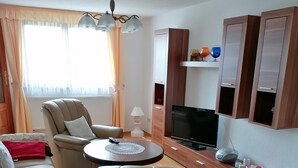 En moderne stue med sofa, lænestol og TV-møbel.