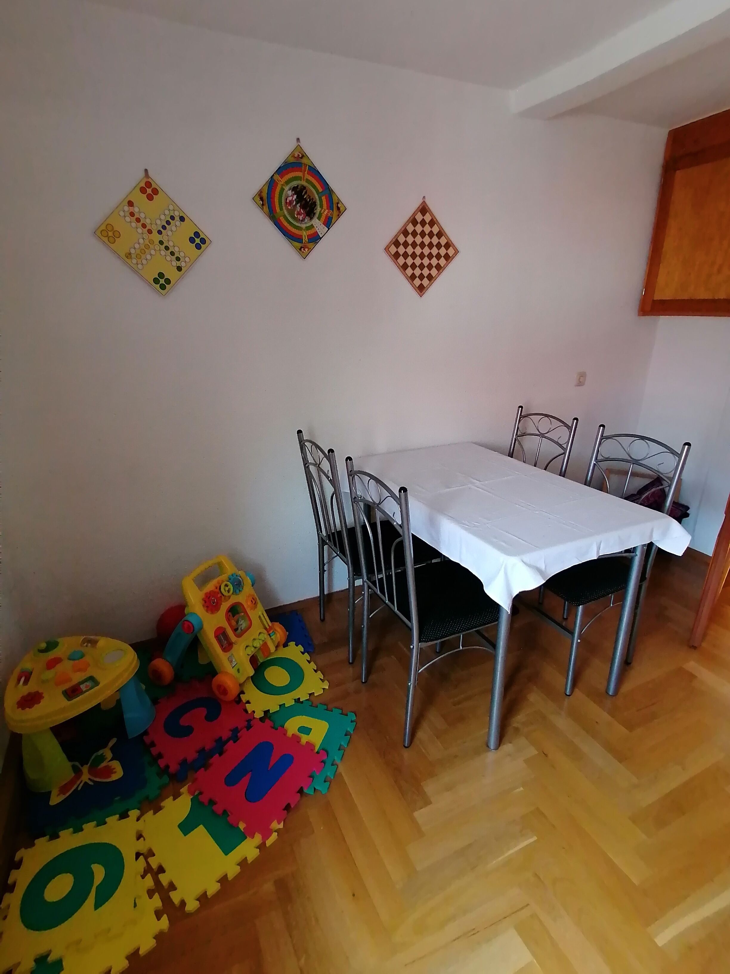 Een eethoek met een tafel, stoelen en kinderspeelgoed.