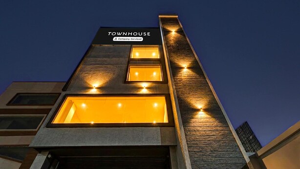 Un edificio moderno con un cartel que dice 'TOWNHOUSE Company-Serviced'.