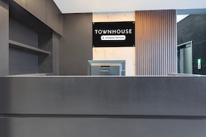 Ein Empfangsbereich mit einem Schild, auf dem 'TOWNHOUSE' und 'Company-Serviced' steht.