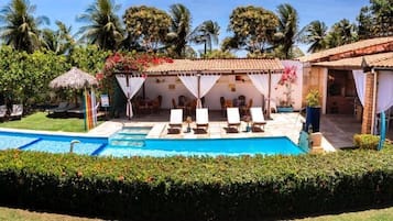 Una piscina al aire libre, sombrillas, tumbonas