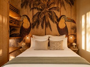 Ein Bett mit weißen Leinen, zwei Kissen und einer grünen Decke.