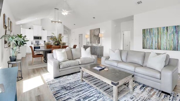 Una sala de estar moderna con un sofá, una mesa de centro y un comedor con sillas y una mesa.