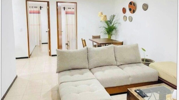 A living room with a sofa, a coffee table, a dining table with chairs, and a plant. - Apartment in the heart of Oaxaca (Oaxaca de Juárez)
