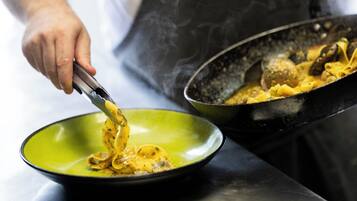 Un chef preparando pasta en una cocina.