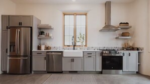Een moderne keuken met roestvrijstalen apparatuur, een raam met uitzicht en lichte kasten.