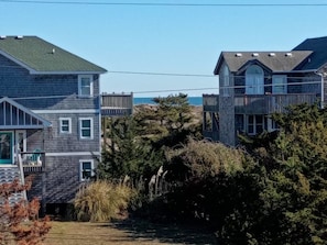 A coastal residential area with houses, a wooden deck, and a view of the ocean.