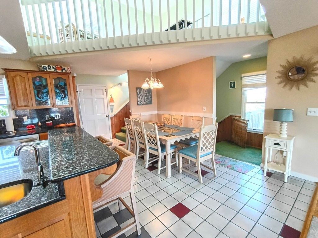 Una cocina con comedor, una escalera y vistas al exterior.