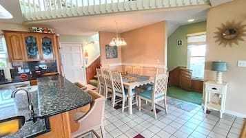 Una cocina con comedor, una escalera y vistas al exterior.