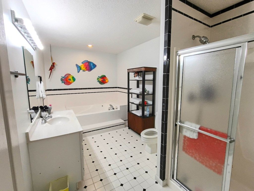 Ein Badezimmer mit weißem Waschbecken, einer Badewanne, einer Toilette und einer Duschkabine.