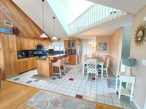 A kitchen with wooden cabinets, a central island, and a dining area with a table and chairs.