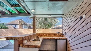 Una cocina compacta con encimera de madera, un fregadero y un refrigerador pequeño.