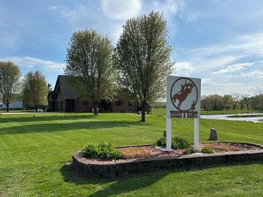 Een bord voor Circle B Ranch met een ruiter op een paard, omgeven door een verzorgd gazon en bomen.