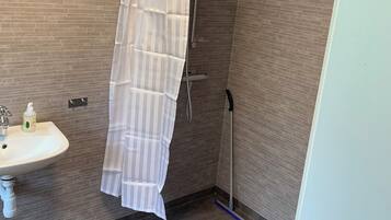 Een douche, handdoeken, zeep, toiletpapier