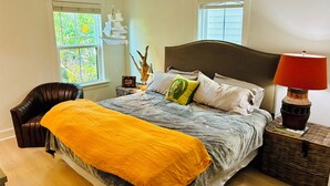 A bedroom with a bed, a chair, a lamp, and a window. - Coastal Retreat Minutes to Sullivans Island and downtown Charleston (Mount Pleasant)