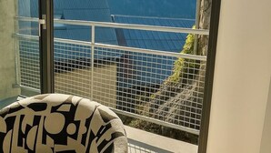 Habitació amb vista a una muntanya a través d'una porta de vidre.
