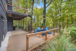 A wooden deck with outdoor seating and a spiral staircase leading to an upper level. - The Post Oak Retreat (Rogers)