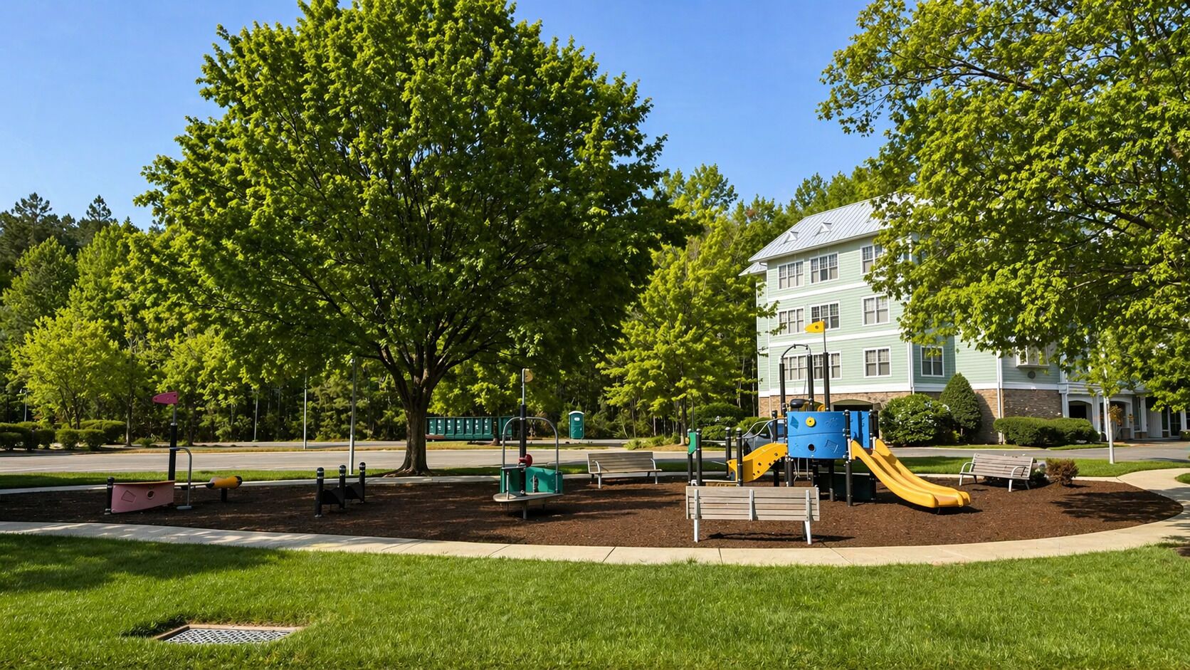 A playground with a slide and swings, surrounded by trees and a building in the background.