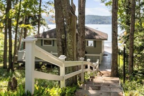 A wooden staircase leading to a house with a view of a lake.