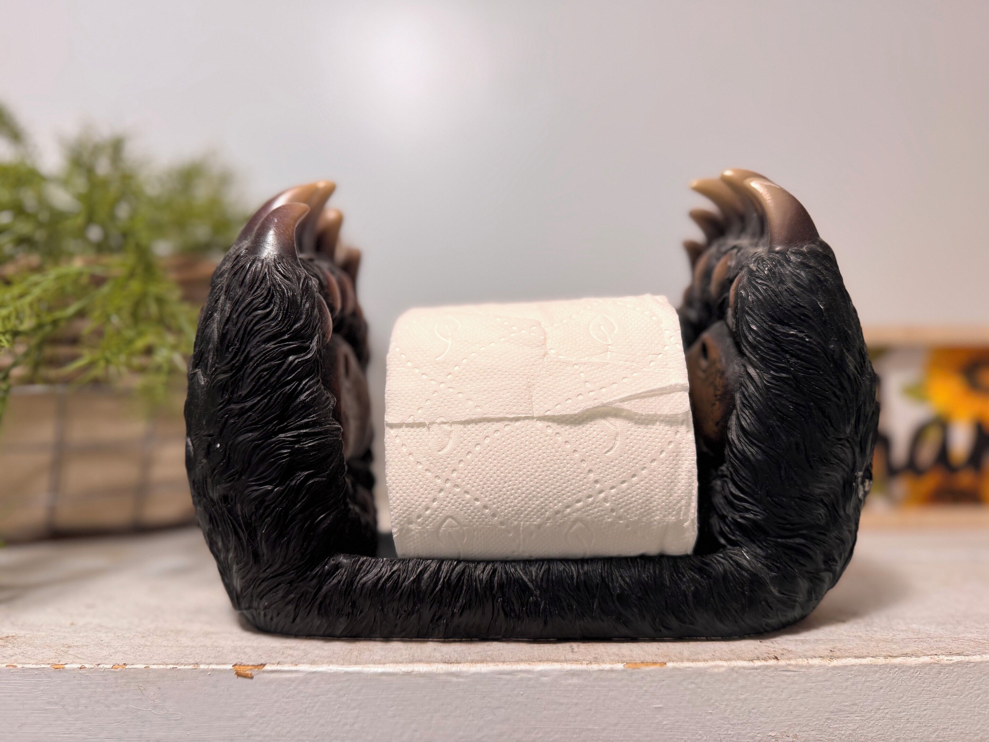 Un peluche de gorila sosteniendo un rollo de papel higiénico.
