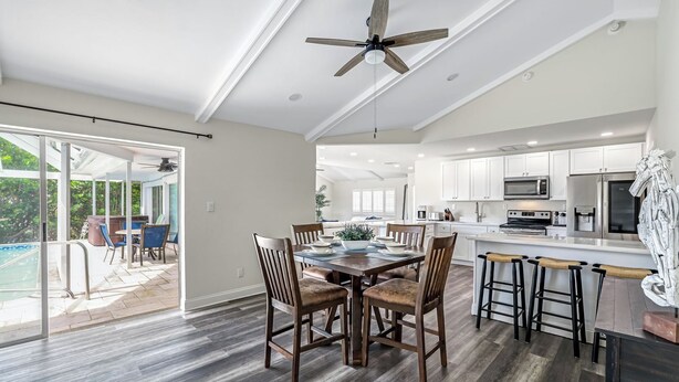 A spacious kitchen with white cabinets, a central island, and a ceiling fan. - Charming 3-bedroom waterfront house in Naples/Marco Island (Naples)