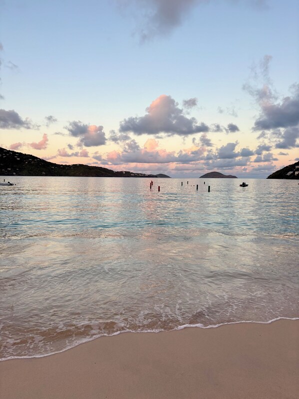 A beach with calm waters, a clear sky, and a distant hill. - Book a getaway by 10/30/26 for 11/2026 and Receive a gift upon check-in! (St Thomas, USVI)