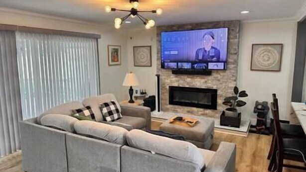 Een woonkamer met een bank, televisie, open haard en een lamp.