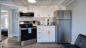 Eine moderne Küche mit weißen Schränken, einem Edelstahlkühlschrank und einem eingebauten Backofen.