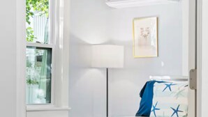 A bedroom with a bed, a window, an air conditioner, and a lamp. - Charming Beachfront Loft | New Renovation (Old Orchard Beach)