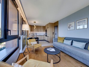 A modern living room with a sofa, chairs, a coffee table, and a view of the kitchen. - Apartment at pistes with spa and parking - Arc 1800 (Les Arcs 1800)