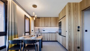 A modern kitchen with wooden paneling, a marble countertop, and pendant lighting. - Apartment at pistes with spa and parking - Arc 1800 (Les Arcs 1800)