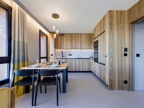 A modern kitchen with wooden paneling, a marble countertop, and pendant lighting. - Apartment at pistes with spa and parking - Arc 1800 (Les Arcs 1800)