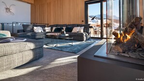 A modern living room with a large sectional sofa, a coffee table, and a fireplace. - Luxury chalet in Les Arcs 1800 with indoor pool and home cinema (Les Arcs 1800)