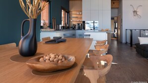 A modern kitchen with wooden cabinets, a central island, and pendant lighting. - Luxury chalet in Les Arcs 1800 with indoor pool and home cinema (Les Arcs 1800)