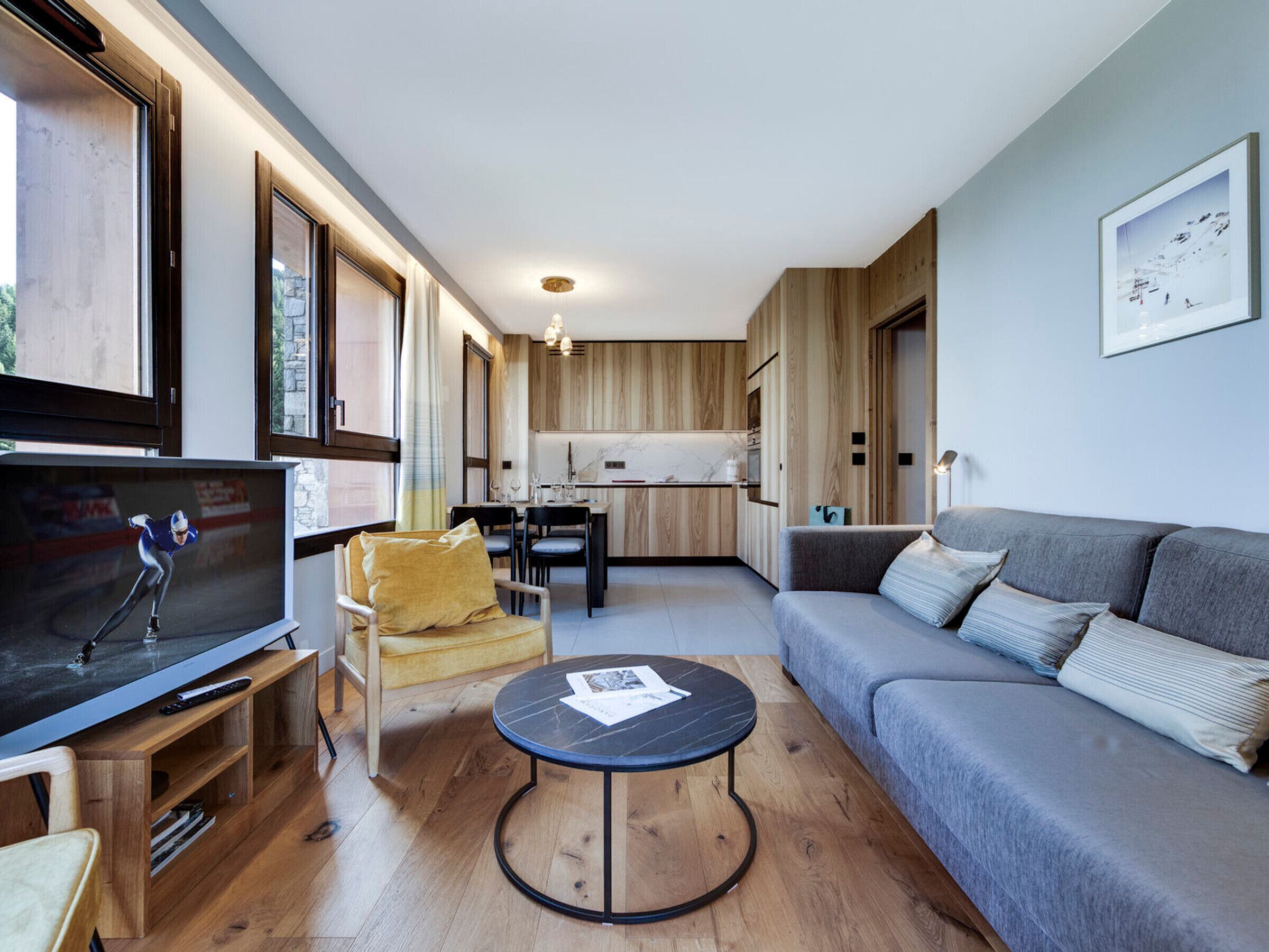 Una sala de estar moderna con televisor, sofá y mesa de centro.
