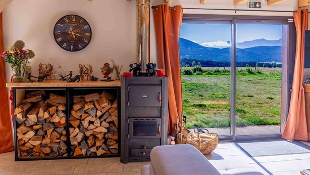 Una camera accogliente con camino, orologio e vista su un paesaggio montano.