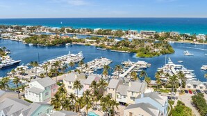 Un puerto deportivo con numerosas embarcaciones amarradas, rodeado de edificios residenciales y palmeras.