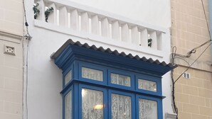 Un edificio de dos pisos con un boquete azul y una puerta azul oscuro.