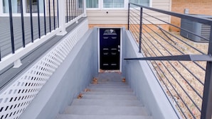 A staircase leading to a dark blue door with a small window above it. - Work & Explore, Cozy Unit 5 Mi to UMD! (Lanham)