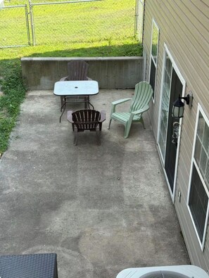 A patio with a table and two chairs, a concrete floor, and a house with a window and a door. - Big Home right off I44 near Fort Leonard Wood (Saint Robert)