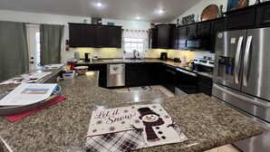 A modern kitchen with dark cabinets, stainless steel appliances, and a granite countertop. - Big Home right off I44 near Fort Leonard Wood (Saint Robert)
