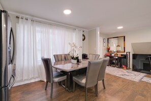 Ein Essbereich mit Tisch, Stühlen und einem Kühlschrank.