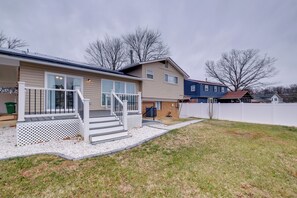 Ein zweistöckiges Haus mit Veranda und einem umzäunten Garten.